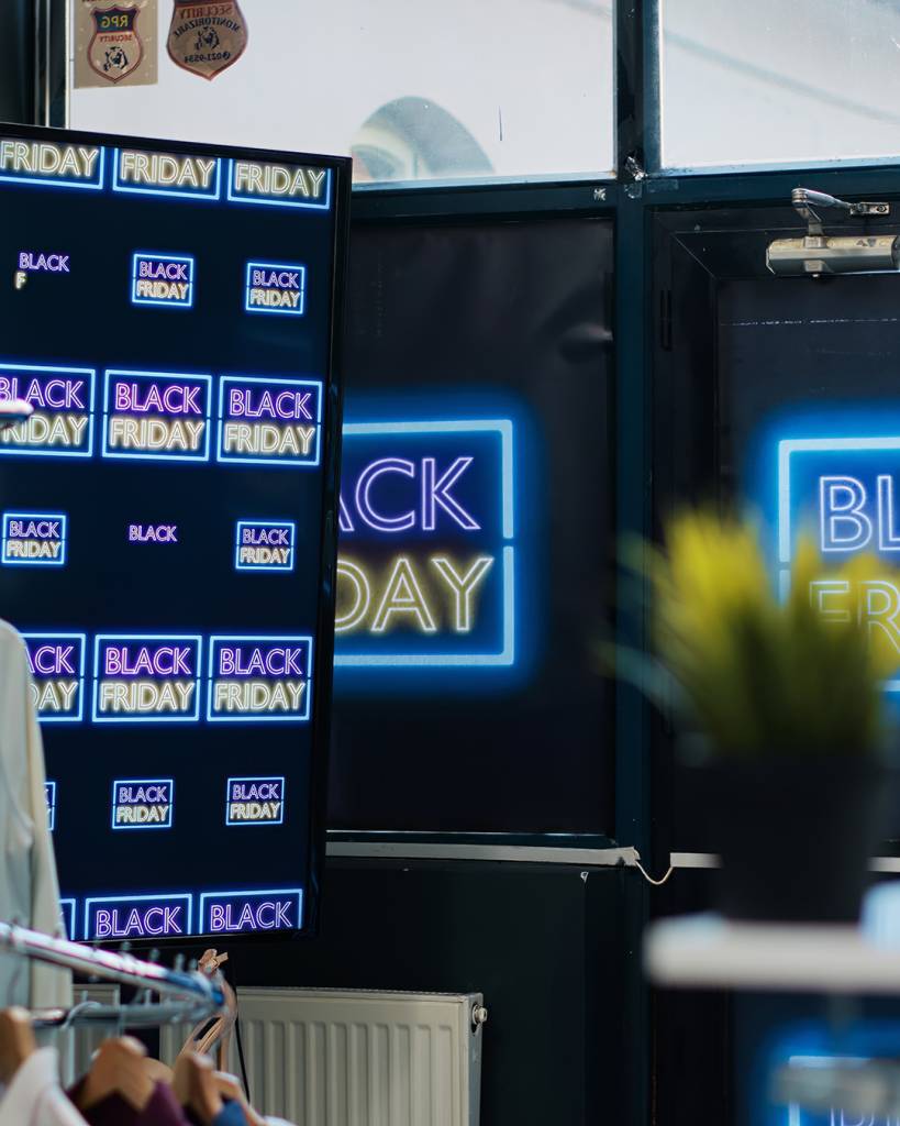 Black friday promotion shopping day inside retail store at mall, front door decorated with promotional banners and discount flyers. Attract potential customers during november sales.