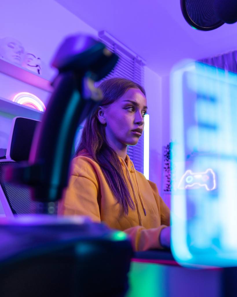 A determined online streamer creates a stream and grows an audience that can generate income through subscriptions and advertising. A contemporary, colorful, and artificially lights home office.