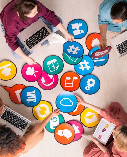 Above view of young social media marketers sitting on floor and using computers while analyzing marketing tools